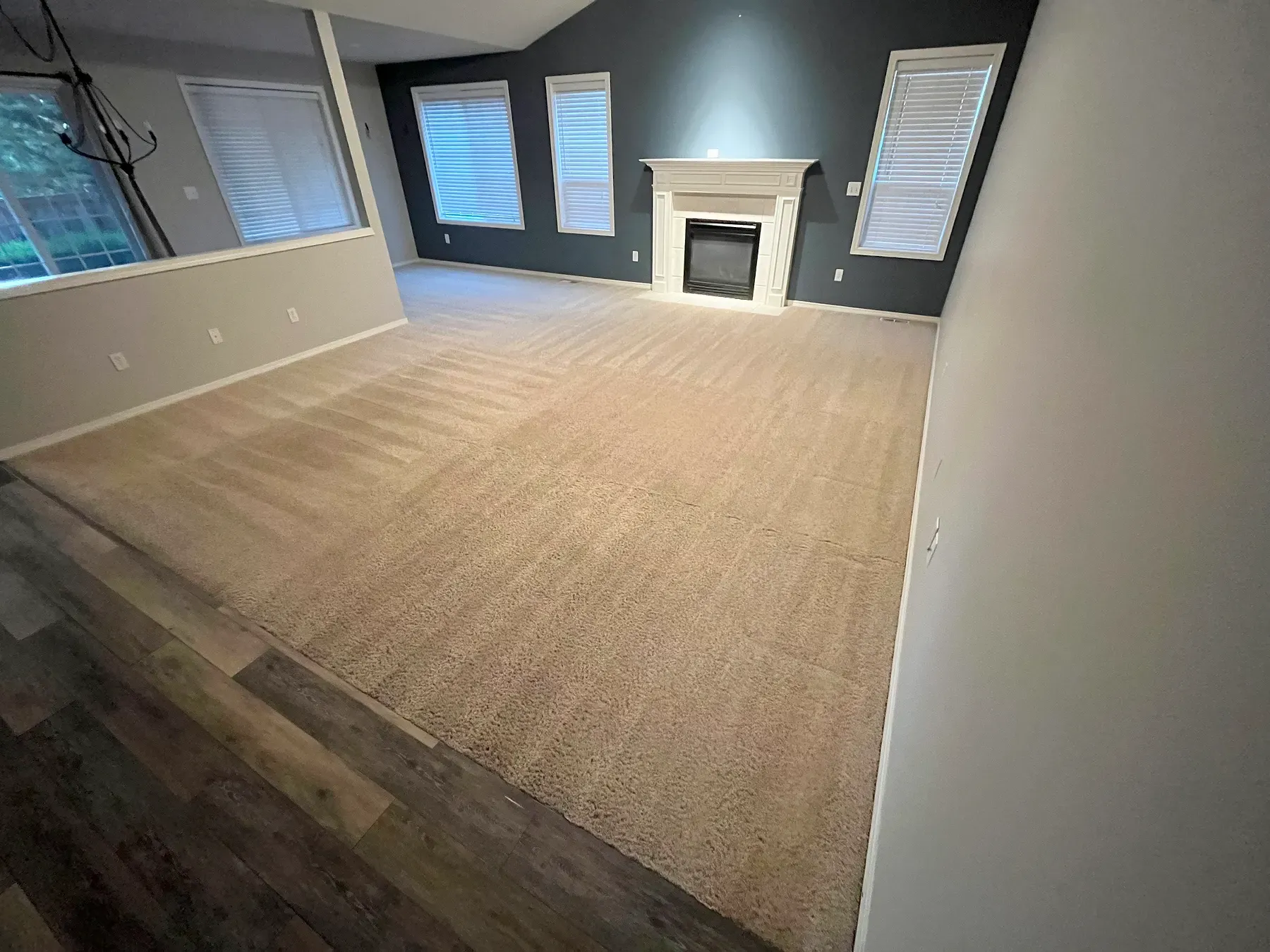 Open living room with freshly cleaned carpet and a white fireplace, cleaned on South Hill